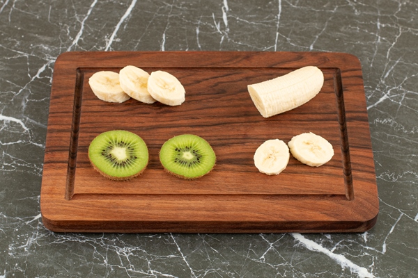 sliced kiwi and banana on wooden board - Банановый смузи