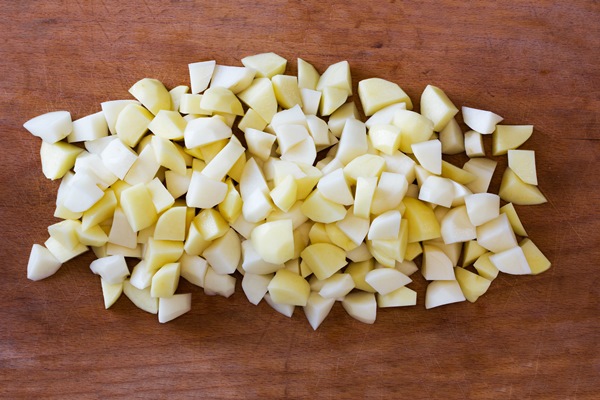 sliced raw potatoes on a old cutting board - Фарш картофельный