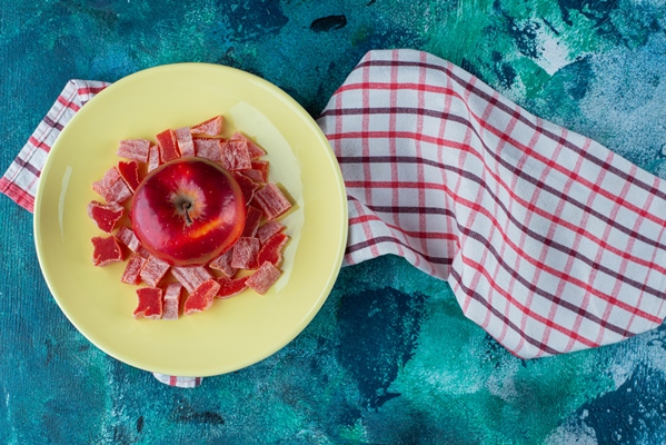 sliced red marmalade and apple in a plate on tea towel on the blue table - Мусс из сырых яблок