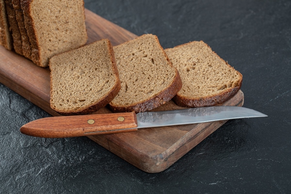 sliced rye bread placed on wooden cutting board - Коврижка из ржаного хлеба (без масла)