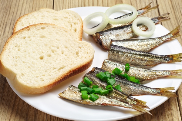 smoked sprats and bread on a white plate - Бутерброд с копчёной рыбой