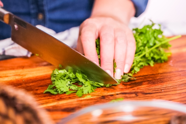 step by step slicing fresh cilantro on a wood cutting board - Соус "Сацебели"
