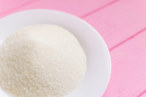 sugar on a white plate on a wooden pink background - Праздничная коврижка