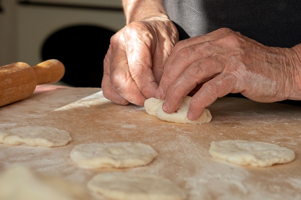 the old woman s overworked hands are making pies out of dough hand made homework with baked goods - Постное тесто на дрожжах, жаренное в масле