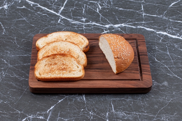 three toasts arranged and bun on the board - Бутерброд с беконом и яйцом