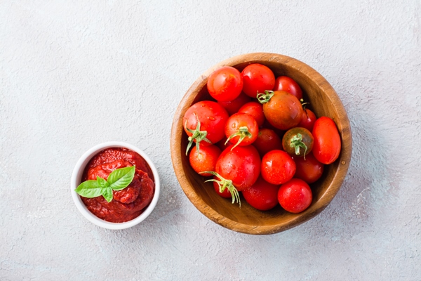 tomato paste and basil leaves in a bowl and tomatoes on a plate on a light background vegetable and vegetarian food vitamins and detox diet top view - Постный рис по-монастырски