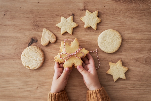top view detail of cookies held by hands of child - Постное печенье на рассоле