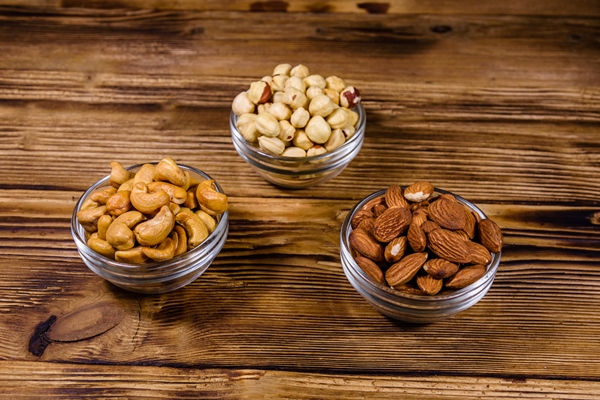 various nuts almond cashew hazelnut in glass bowls on a wooden table vegetarian meal healthy eating concept - Домашний хлеб из льняной муки