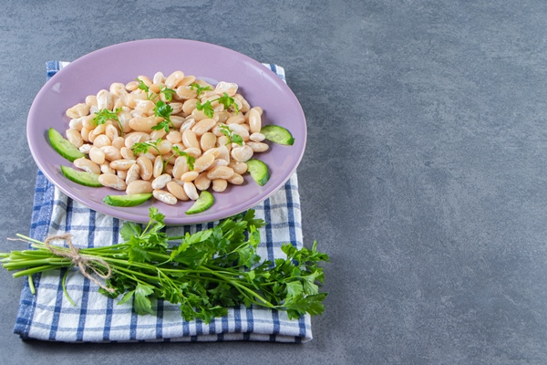 white beans with cucumber on a plate next to parsley brunch on a towel on the marble background 1 - Соус из белых бобов