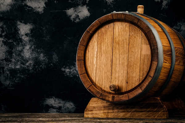 a beautiful wooden barrel and a worn oak wood table set against a dark wall pattern for the design - Замоскворецкий квас