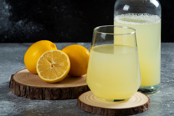 a cup of lemon juice on wooden board - Квас царский