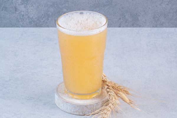 a glass of beer with wheat on white surface - Видземский напиток
