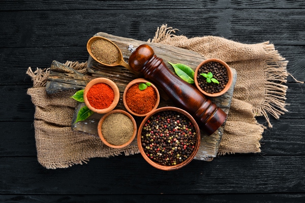 a set of peppers black pepper colored pepper ground pepper dried chili pepper top view on a black background free space for your - Драники с овсяными хлопьями