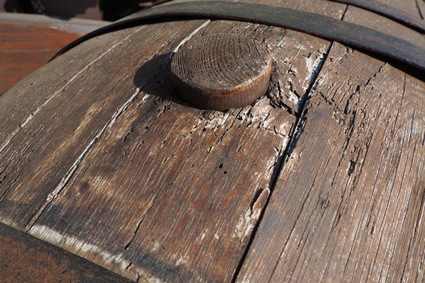 a traditional old wooden barrel with curved walls and metal hoops dishes for the ripening of alcoholic beverages mead beer wine whiskey a rollable cylindrical vessel for liquid substances - Маринин квас