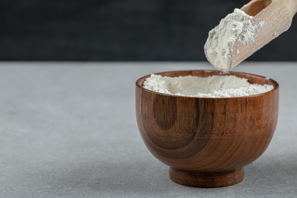 a wooden bowl of flour and wooden spoon - Суп-рассольник с перловкой