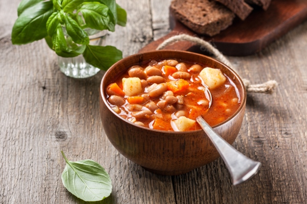 bean soup in a wooden bowl on the old wooden background - Суп фасолевый с томатом