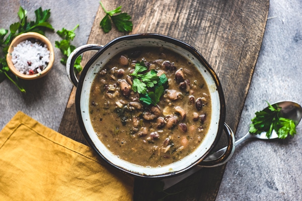 bean soup served in a ceramic bowl on rustic table - Суп из фасоли с орехами