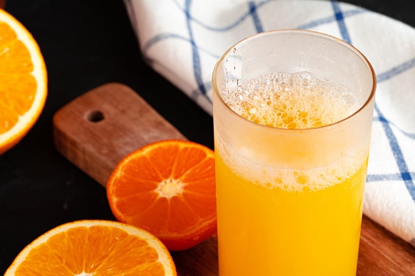 close up of orange juice glass on wooden table - Апельсиновый квас