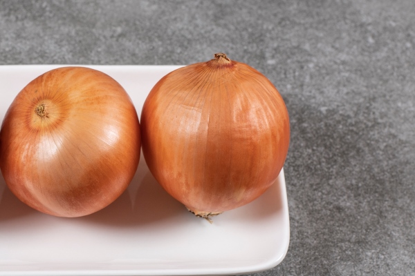 close up photo of fresh ripe onions on white plate - Постный суп из чечевицы с баклажанами
