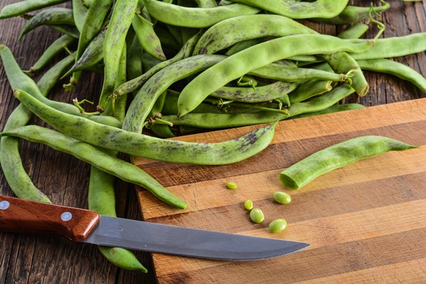 cutting of green beans pods on a chopping board - Суп овощной постный