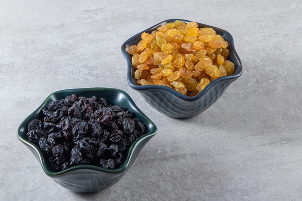 dark bowls with dried golden and black raisins on stone background 1 - Кутья рисовая с мёдом и сахаром