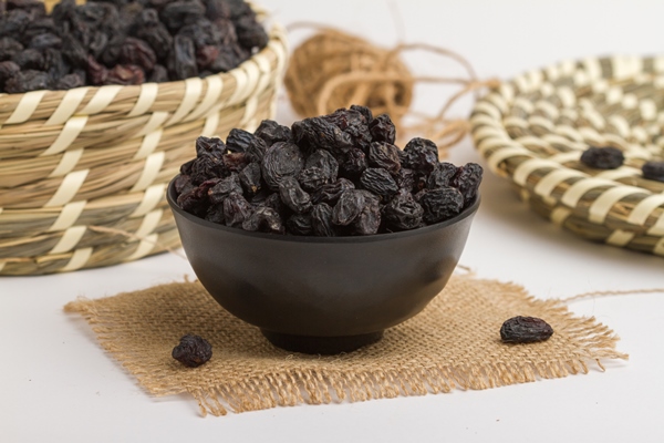 dried black grapes served in bowl isolated on napkin side view of dry fruits on grey background - Лечебный квас