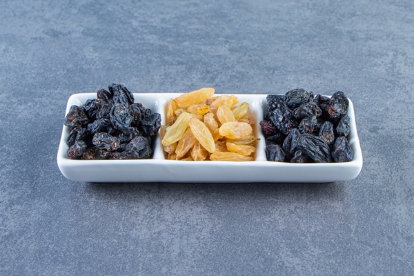 flavorful raisins on a dish on the marble surface - Вишнёвый квас