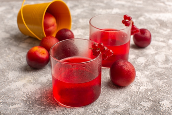 front view of cranberry juice red colored on the light surface - Квас из фруктового сока