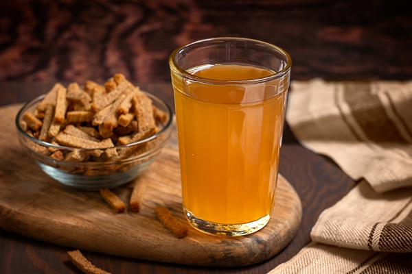 glass of homemade refreshing cereal based low alcoholic fermented kvass with sour taste on table - Славянский квас