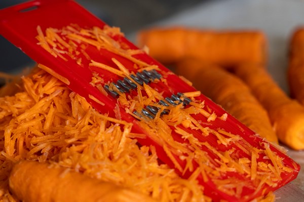 grating carrots on a grater for korean carrots lifestyle cooking healthy eating - Драники с морковью и луком