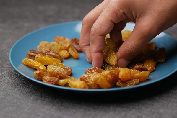 hand pick big size raisin on hand close up - Суздальский квас