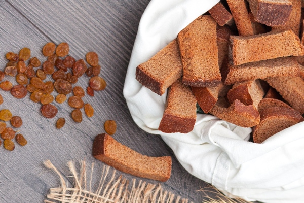 kvas in glass with rye bread and raisins on wooden background - Сухарный квас