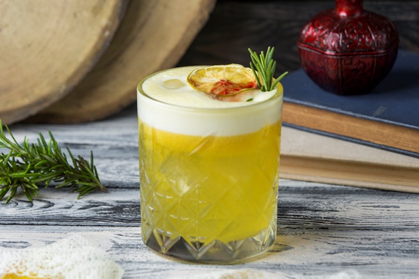 lemon drink garnished with dried lemon slice rosemarine in crystal glass - Нащёкинский квас