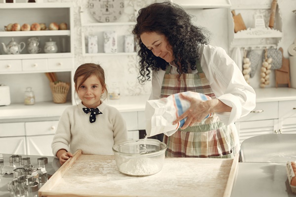 people in a kitchen grandmother with little daughter adult woman teach little girl to cook - Хлеб домашний на свежих дрожжах