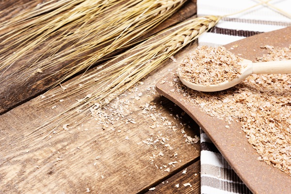 plate and spoon filled wheat bran next to wheat ears on wood table healthy eating concept - Квас-борщ (румынская кухня)