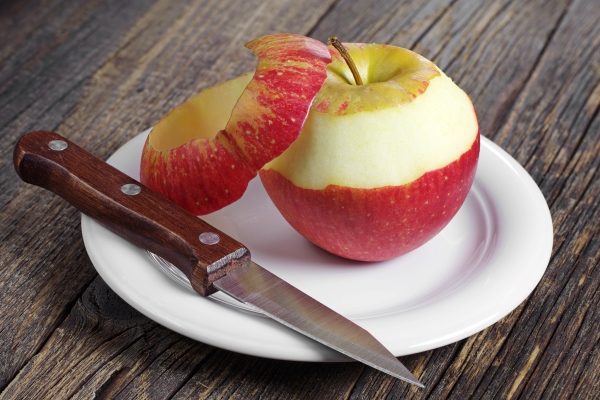 red apple peeled and knife in plate on wooden table - Полезные советы по приготовлению квасов