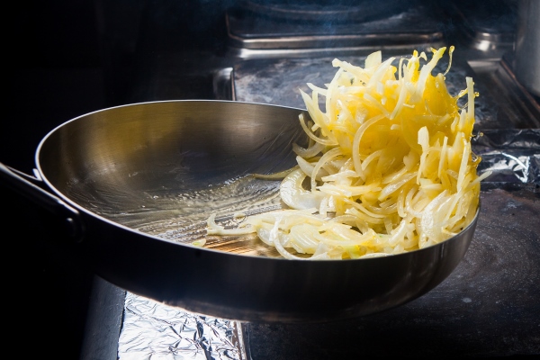 side view frying onions with pan in stove - Суп с белыми грибами, постный