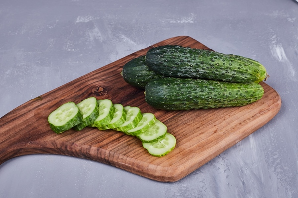 sliced cucumber or pickles on a wooden board top view - Ботвинья по-монастырски