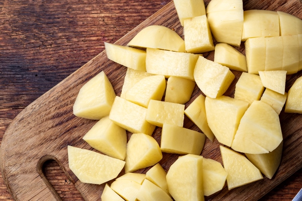 sliced raw potatoes on a wooden background preparation for cooking - Суп картофельный с горохом