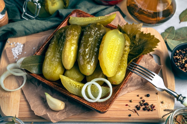 spicy pickled cucumbers with onions on a wooden cutting board on a gray background the concept of culinary backgrounds - Суп-рассольник с перловкой