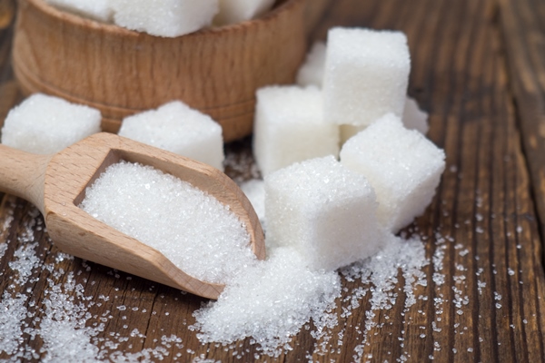 stack of sugar cubes and granulated sugar in a wooden scoop - Шипучий квас