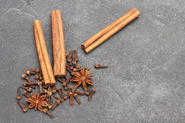 star anise and cinnamon sticks cloves on black flat lay copy space - Квас золотистый из моркови