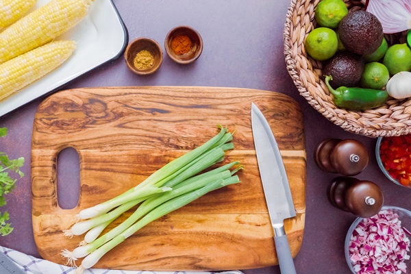 step by step slicing green onions on a wood cutting board - Драники с зеленью и луком