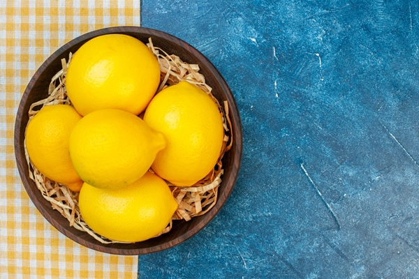 top view fresh yellow lemons inside plate on blue wall - Замоскворецкий квас