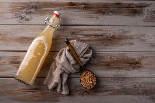 top view homemade traditional russian light rye kvass in bottle and linen napkin on wooden - Квас суточный