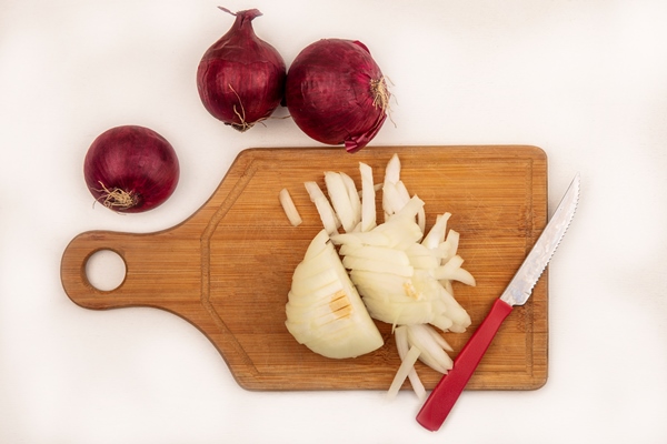 top view of fresh white onion on a wooden kitchen board with knife with red onions isolated on a white surface - Суп-пюре из лука, постный
