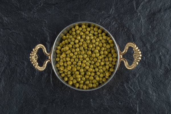 top view of metal pan full with green peas - Суп картофельный с бобовыми