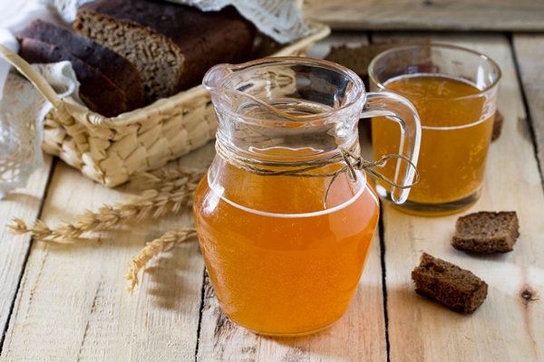 traditional russian cold rye drink kvas in a glass and a jug on the kitchen table in a rustic style - Орловский квас