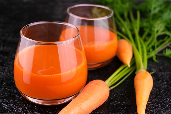 useful carrot juice in glasses on a black background - Квас золотистый из моркови