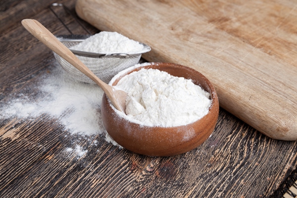 wheat flour in a wooden bowl 1 - Деруны с чесноком
